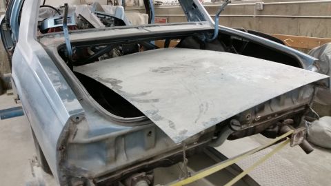 2001 Ford Crown Victoria - Photograph of a trunk lid on a stripped car body during bodywork, not a technical document.