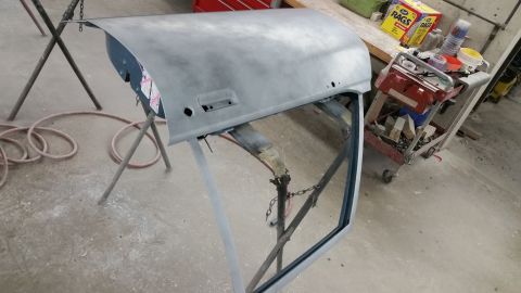 2001 Ford Crown Victoria - Photograph of a primed body panel on stands during restoration, not a technical document.