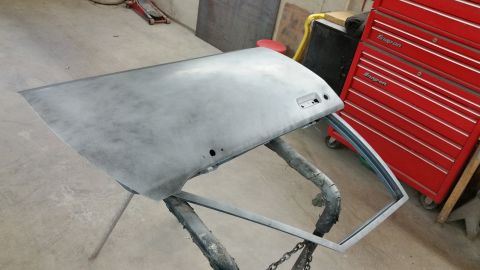 2001 Ford Crown Victoria - Photo of a primered automotive door panel on a work stand, not a technical document.