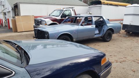 2001 Ford Crown Victoria - Photo of project cars parked in a yard, not a technical document.