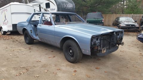 2001 Ford Crown Victoria - Photo of a project sedan with stripped front end outdoors, not a document.