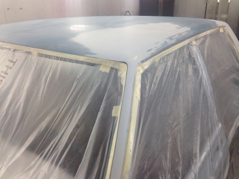 2001 Ford Crown Victoria - Photo of a masked, primered roof in a paint booth, not a document.