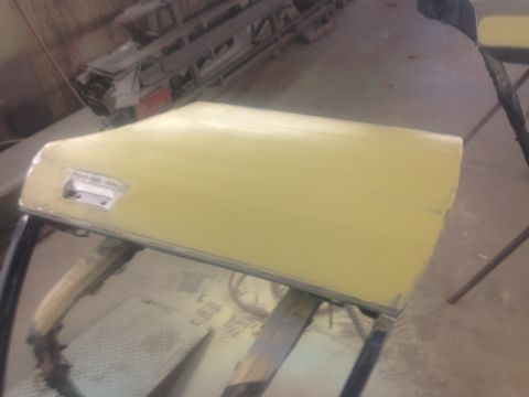 2001 Ford Crown Victoria - Photo of a door panel with body filler on supports, not a document.