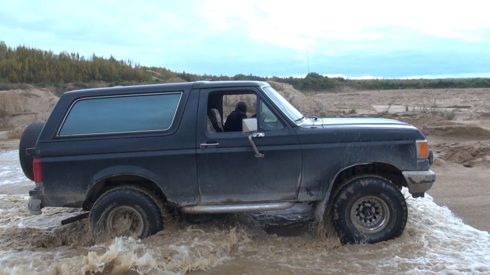 Dark Ford Bronco driving through water