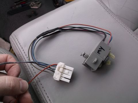 1999 Mercury Grand Marquis - A close-up view shows a custom wiring harness with a white connector on one end and a gray electrical component with the handwritten label…