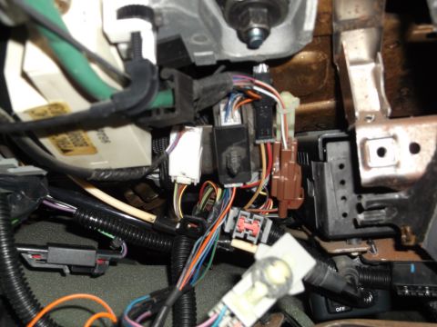 1999 Mercury Grand Marquis - A close-up view of wiring harnesses and connectors under the dashboard of a vehicle. Several electrical components and bundles of colorful…