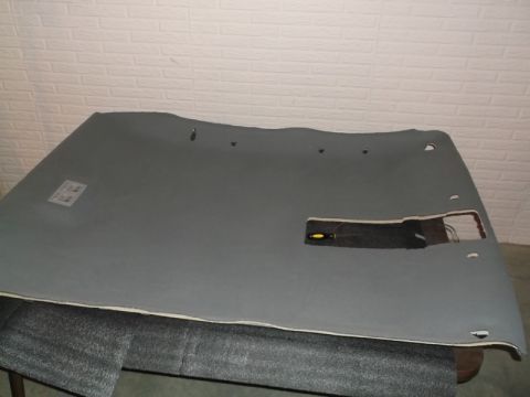 1999 Mercury Grand Marquis - The underside of a car's headliner is shown, with cutouts for lights and other components. A yellow and black screwdriver rests within one…
