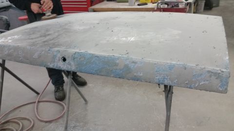 2001 Ford Crown Victoria - Photo of a primered hood panel during sanding, not a document.