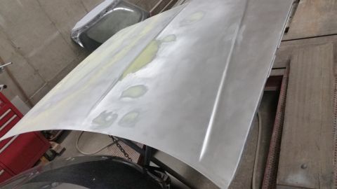 2001 Ford Crown Victoria - Photo of a hood panel with filler spots during bodywork, not a document.
