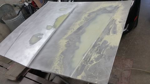 2001 Ford Crown Victoria - Photo of a hood panel with body filler during prep, not a document.