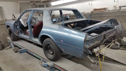 2001 Ford Crown Victoria - Photo of a sedan body shell on a frame rack, not a technical document.