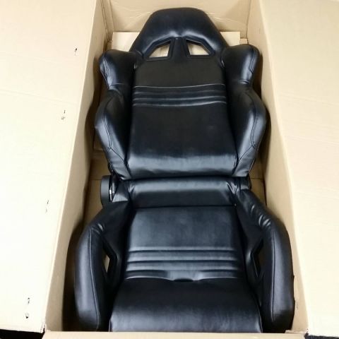 2003 Ford Crown Victoria - Photograph of a black racing bucket seat in a box, not a technical document.