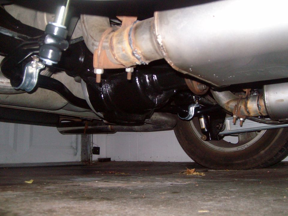 Underside view of a vehicle's rear differential and exhaust system.