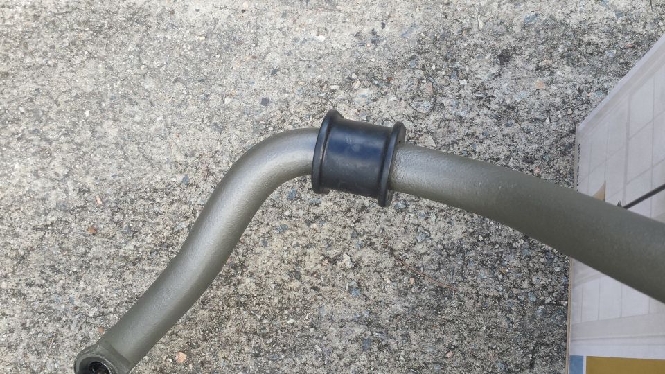 Gray sway bar with black bushing on concrete