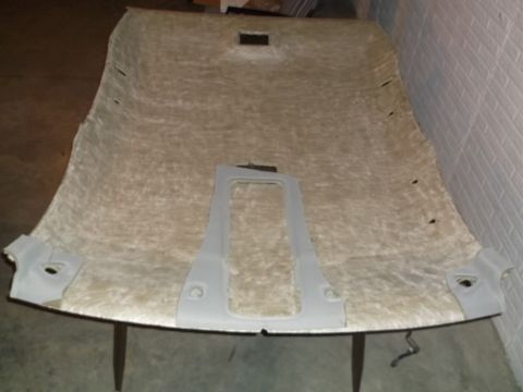 1999 Mercury Grand Marquis - The underside of a car's headliner is shown, possibly removed for repair or modification. Several grey plastic trim pieces are attached to…
