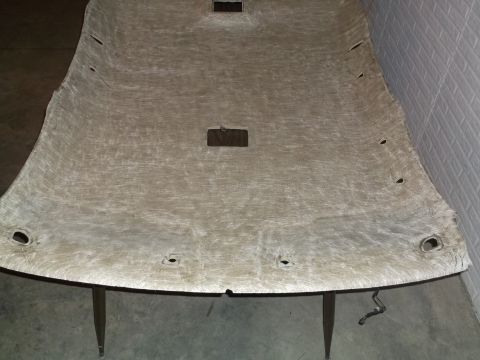 1999 Mercury Grand Marquis - This is a close-up, overhead view of a detached car headliner, likely from a 1999 Mercury Grand Marquis. The headliner is a light tan color…