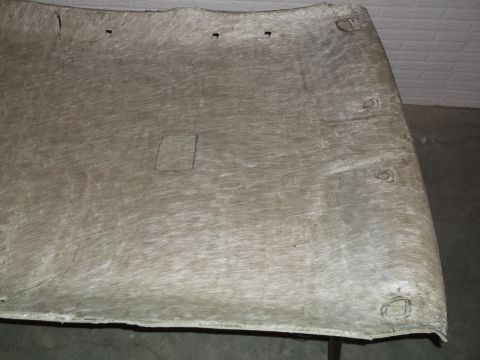 1999 Mercury Grand Marquis - The underside of a car's headliner is shown, with cutouts for mounting points and a square opening for a light or speaker. The material app…