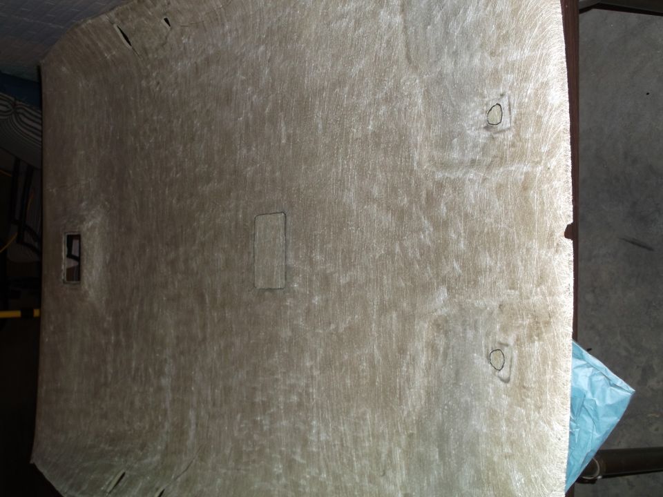 Underside of a beige vehicle headliner with cutouts