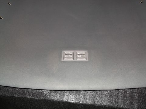 1999 Mercury Grand Marquis - A close-up view of the grey headliner in a vehicle, featuring a dual-lens interior light fixture.