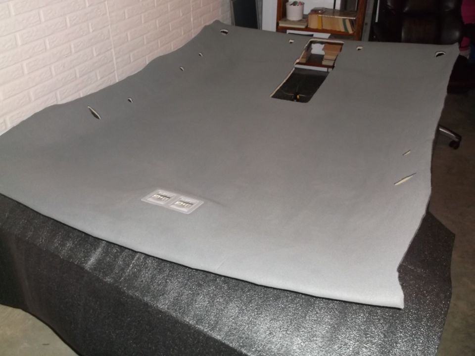 Gray headliner with cutouts for lights and sunroof, possibly for a 1999 Mercury Grand Marquis.
