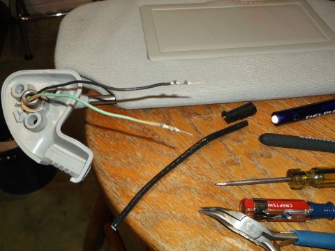 1999 Mercury Grand Marquis - A close-up view of wiring being worked on, likely for a car part, with various tools including pliers and screwdrivers laid out on a wooden…