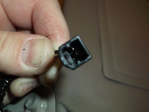 1999 Mercury Grand Marquis - A close-up shot shows a person's thumb and forefinger holding a black electrical connector with exposed wires. The connector appears to be…