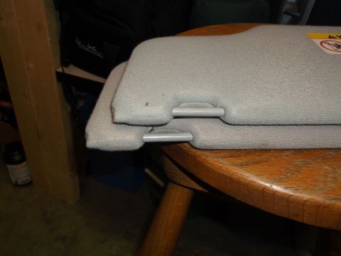 1999 Mercury Grand Marquis - Two gray sun visors are stacked on a wooden table. The visors appear to be from a car, with visible clips on the bottom one.