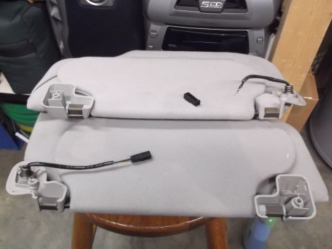 1999 Mercury Grand Marquis - Car sun visors removed from vehicle, showing detached wiring and mounting hardware.