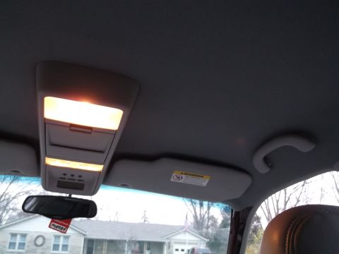 1999 Mercury Grand Marquis - Interior view of a car's overhead console and rearview mirror, with a glimpse of the exterior through the windshield.