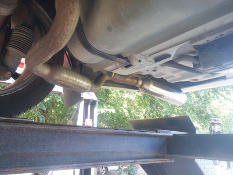 2000 Mercury Grand Marquis - The underside of a vehicle is visible, including the exhaust system and fuel tank, while on a lift.