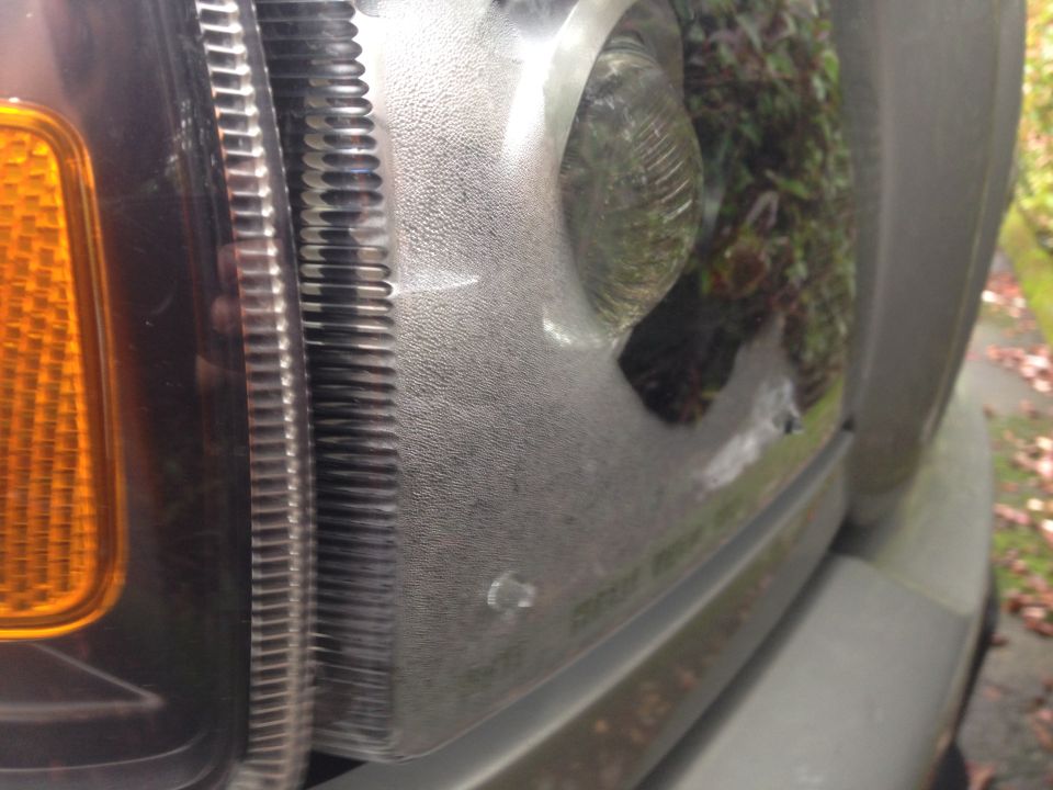 Truck headlight assembly with amber turn signal, showing condensation inside the lens and minor scuffs