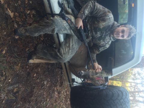 1974 Ford Bronco - Hunter poses with a deer in the back of a white pickup truck after a hunt.