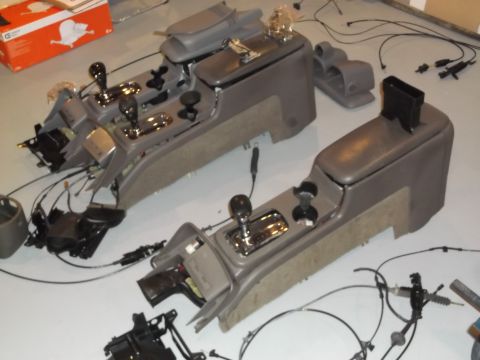 1999 Mercury Grand Marquis - Disassembled car center consoles are laid out on the floor, showing their internal components and wiring.