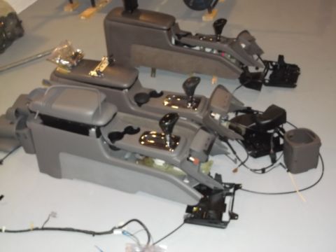 1999 Mercury Grand Marquis - Two car center consoles are shown disassembled, with gear shifters and wiring visible.