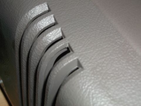 1999 Mercury Grand Marquis - Detail of the interior trim, showing a series of parallel, curved slots in the textured plastic.