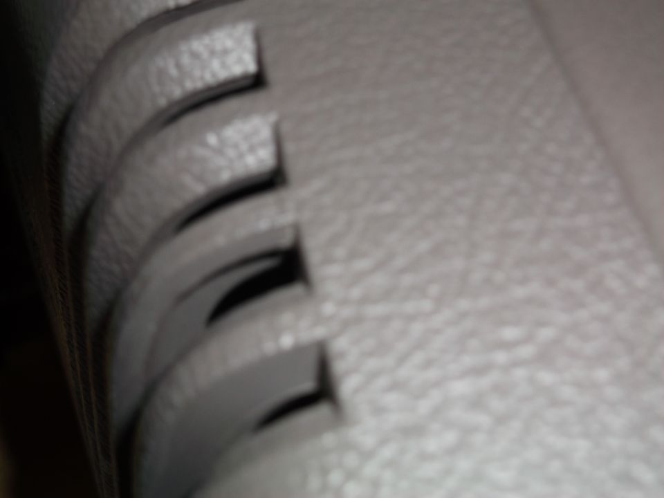 Gray textured car interior console with curved slots and a Supermotors.net watermark
