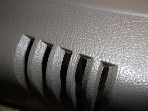 1999 Mercury Grand Marquis - Close-up of a gray interior console vent showing a crack in the plastic.