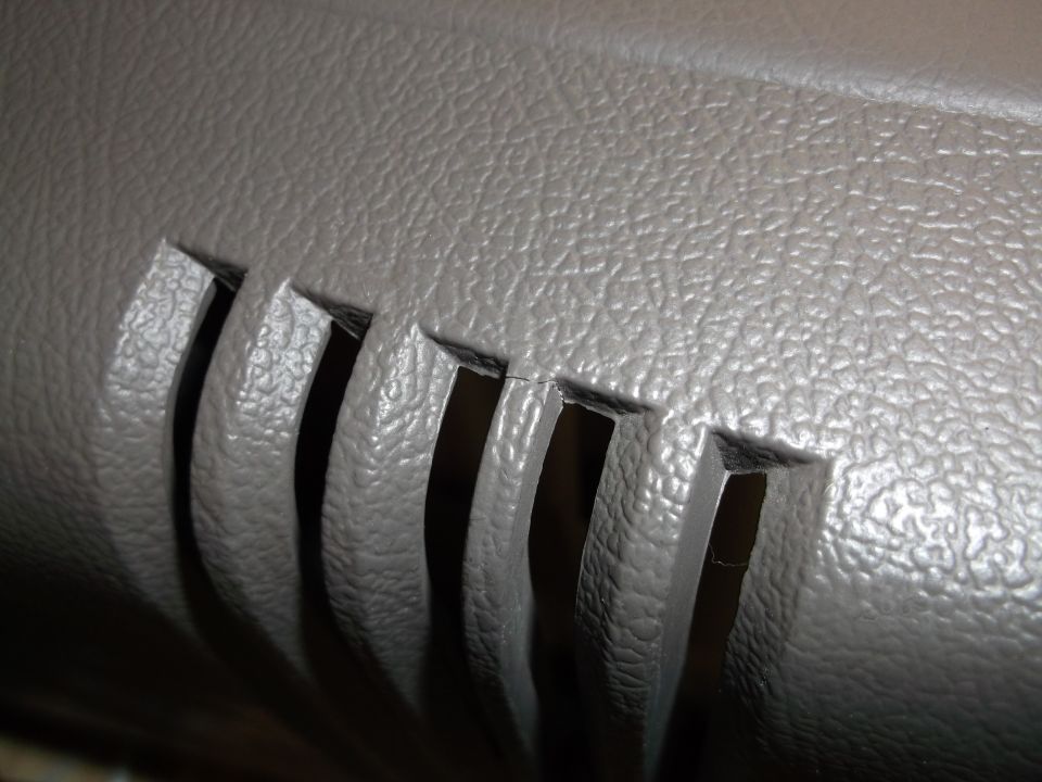 Gray interior console vent with visible crack