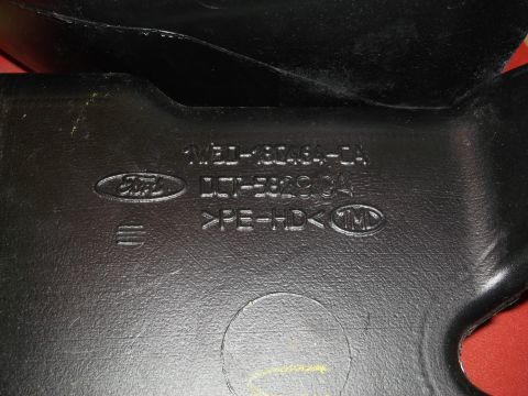 1999 Mercury Grand Marquis - This black plastic automotive part displays the Ford logo and various part numbers, including '1M3J-18C246-CA'.