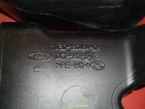 1999 Mercury Grand Marquis - A black plastic automotive part with Ford branding and part numbers is shown up close.