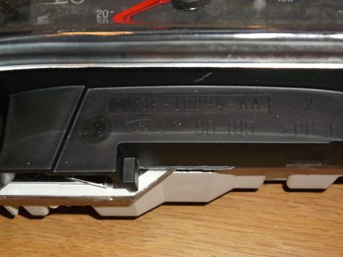 1999 Mercury Grand Marquis - A close-up view of a vehicle's instrument cluster housing, showing part numbers and manufacturing codes.