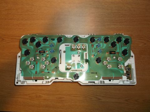 1999 Mercury Grand Marquis - The back of a printed circuit board from a 1999 Mercury Grand Marquis instrument cluster is shown, mounted on a wooden surface. The board f…