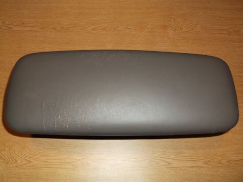 1999 Mercury Grand Marquis - A gray, padded armrest lid is shown from a top-down, straight-on angle. The lid is resting on a wooden surface.