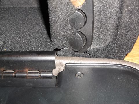 1999 Mercury Grand Marquis - A close-up view shows the interior hinge mechanism and textured upholstery of what appears to be a car's center console or armrest. A small…