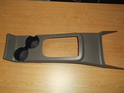 1999 Mercury Grand Marquis - A gray plastic center console trim piece with two cup holders and a large rectangular opening is shown on a wooden surface.