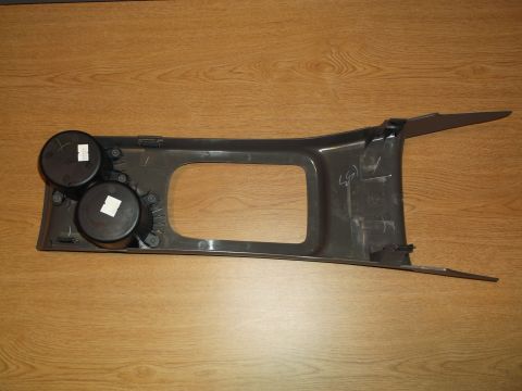 1999 Mercury Grand Marquis - A dark gray plastic center console trim piece with two cup holders is shown against a wooden background. The piece has an open rectangular…
