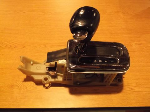 1999 Mercury Grand Marquis - A close-up, overhead view of a black automatic transmission shifter assembly with a chrome bezel and a digital display showing P, R, N, D,…
