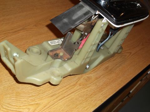 1999 Mercury Grand Marquis - This is a close-up, angled shot of a car's automatic transmission shifter assembly, likely from the driver's side interior, resting on a wo…