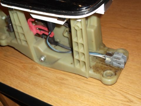1999 Mercury Grand Marquis - This is a close-up, angled view of the internal mechanism of a car's gear shifter assembly. The beige plastic housing is visible, along wit…
