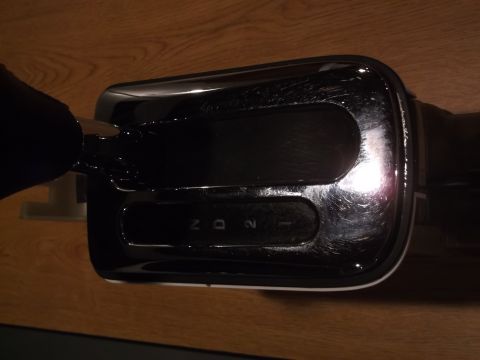 1999 Mercury Grand Marquis - A close-up view of a black automatic transmission shifter with visible gear selections (N, D, 2) illuminated on a wooden surface.